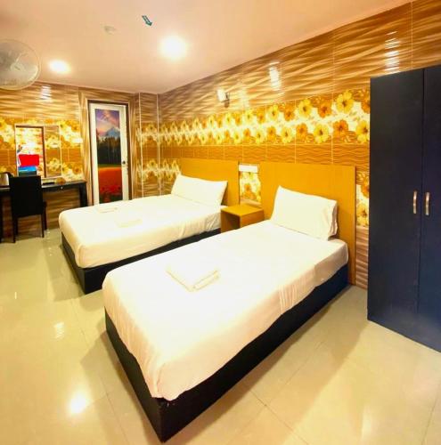 a hotel room with two beds and a desk with a desk at Cameron Kea Farm Hotel in Brinchang