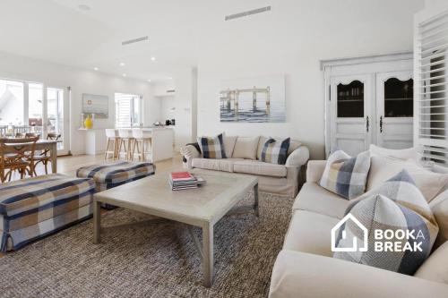 a living room with a couch and a table at Clovelly of Portsea - Heated Pool Spa Luxury in Portsea