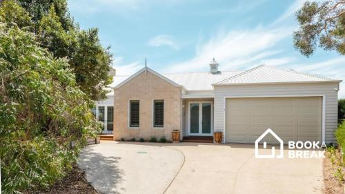 a house with a garage in front of it at Clovelly of Portsea - Heated Pool Spa Luxury in Portsea
