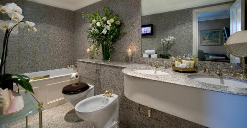 a bathroom with two sinks and a vase of flowers at Egerton House in London