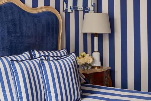 a bedroom with a bed with blue and white stripes at Egerton House in London