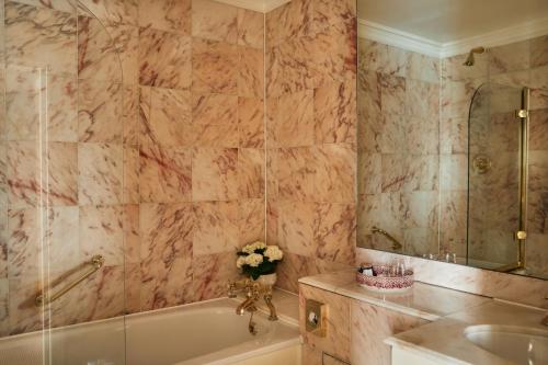 a bathroom with a bath tub and a sink at Egerton House in London