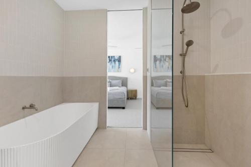 a bathroom with a bath tub and a bedroom at Villa Aquarius - Gas Heated Pool Spa Luxury in Blairgowrie