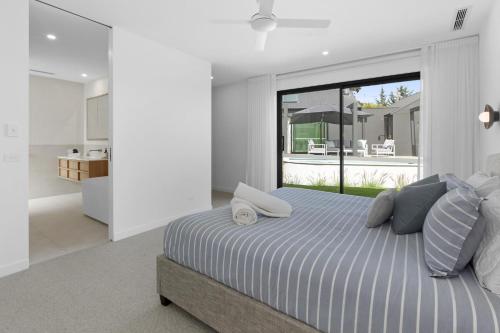 a bedroom with a large bed and a large window at Villa Aquarius - Gas Heated Pool Spa Luxury in Blairgowrie