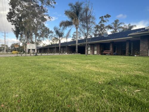 a building with a grass field in front of it at Two Rivers Motel in Wentworth
