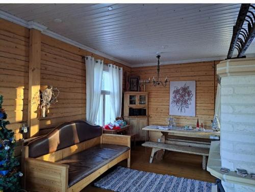 a room with a bench and a table and a christmas tree at tunnelmallinen vapaaajanpaikka in Toiviaiskylä
