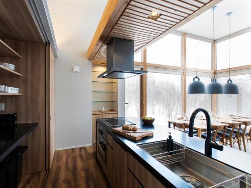 a kitchen with a sink and a large window at Chalet Ukiyo in Niseko