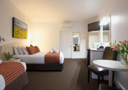 a hotel room with two beds and a kitchen at Bowen Inn Motel in Lithgow