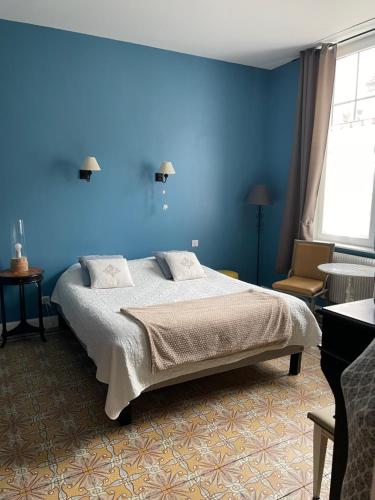 a blue bedroom with a bed and a blue wall at Au Bois Dormant in Huby-Saint-Leu