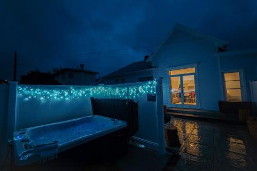 a bath tub sitting on the side of a house with lights at The Villa in Hastings