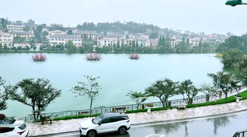 a white car parked next to a large body of water at Sapa Lake View Hotel in Sa Pa