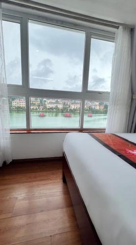 a bedroom with a large window with a view of the water at Sapa Lake View Hotel in Sa Pa