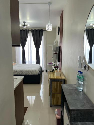 a hotel room with a bed and a bathroom at L L I Condotel in Lapu Lapu City