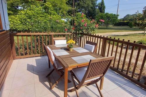 a wooden table and chairs on a deck at Chalet cosy avec piscine en campagne in Condom