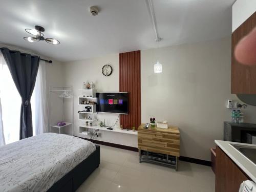 ein Schlafzimmer mit einem Bett und einem Flachbildfernseher in der Unterkunft L L I Condotel in Lapu Lapu City