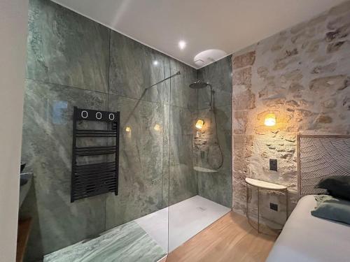 La salle de bains est pourvue d'une douche et d'une paroi en verre. dans l'établissement Louvre -Notre Dame 2BD, 2BATH AC, à Paris