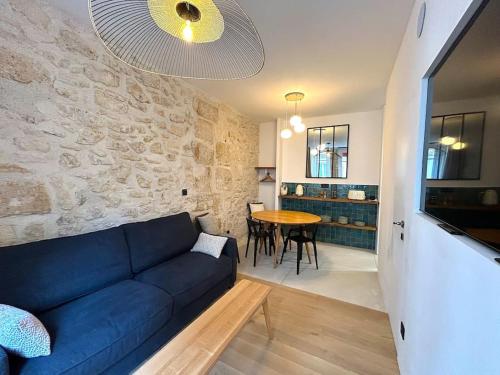 un salon avec un canapé bleu et une table dans l'établissement Louvre -Notre Dame 2BD, 2BATH AC, à Paris