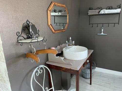 a bathroom with a sink and a mirror at Au Bois Dormant in Huby-Saint-Leu