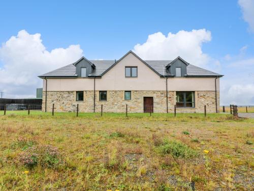 a large stone house on a grass field at The Barn, Drumbow Farm in Airdrie