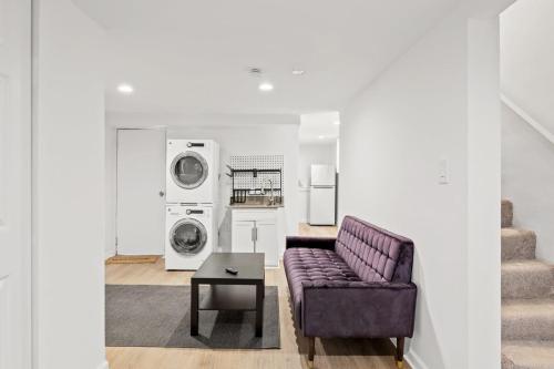 a living room with a purple couch and a washing machine at Negin 2903 - Basement Unit in Washington, D.C.