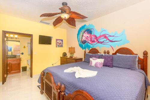 a bedroom with a bed and a ceiling fan at Del Playa #3 Condo in West End