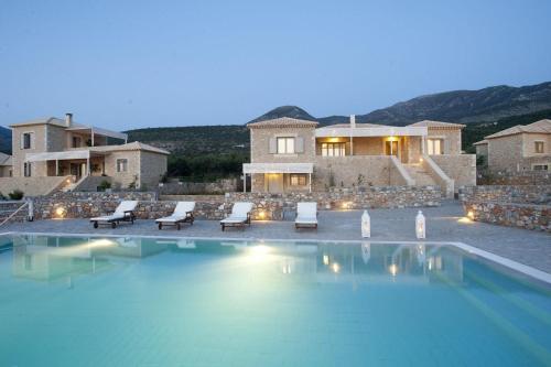 a villa with a swimming pool at night at Poliana Estate Villas in Riglia