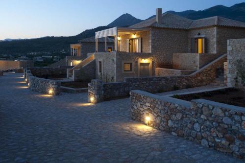 a house with lights in front of a building at Poliana Estate Villas in Riglia