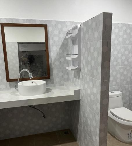 a bathroom with a sink and a mirror and a toilet at BaanPhong Lanta in Ko Lanta