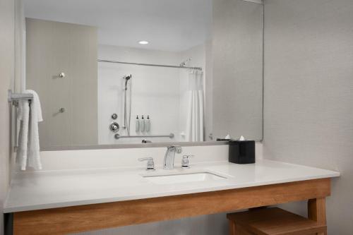 a bathroom with a sink and a large mirror at Courtyard by Marriott Philadelphia Bensalem in Bensalem