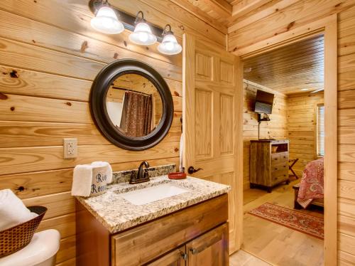 a bathroom with a sink and a mirror in a log cabin at River Romance #2328 in Pigeon Forge