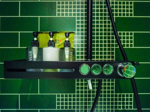 a shelf with alcohol bottles on a green wall at 秋果酒店-重庆两江幸福广场店 in Chongqing