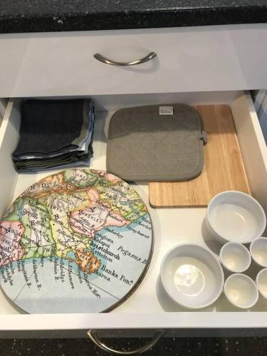 a drawer with a plate and some dishes in it at Brookside Country Escape 40 minutes to CHC Airport in Leeston