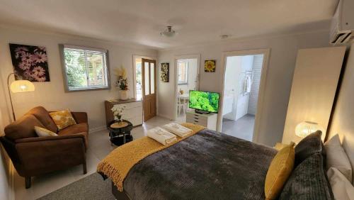 a bedroom with a large bed and a living room at Riesling Trail & Clare Valley Cottages in Clare