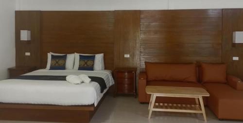 a bedroom with a bed and a couch at BaanPhong Lanta in Ko Lanta