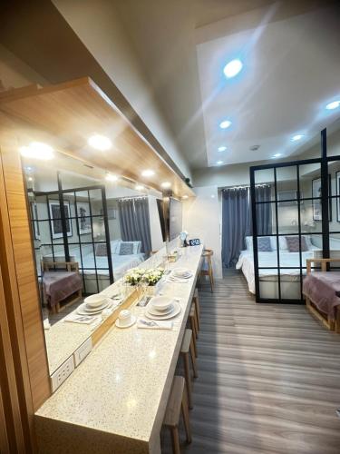 ein Hotelzimmer mit einem langen Tisch und zwei Betten in der Unterkunft Avida Riala It Park Fast wifi in Cebu City