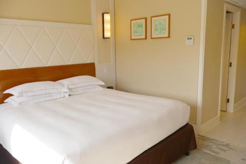 a bedroom with a large white bed with two pillows at Hilton Guam Resort & Spa in Tumon