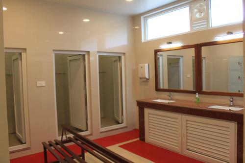 a bathroom with two sinks and two mirrors at Windermere Hotel in Shillong