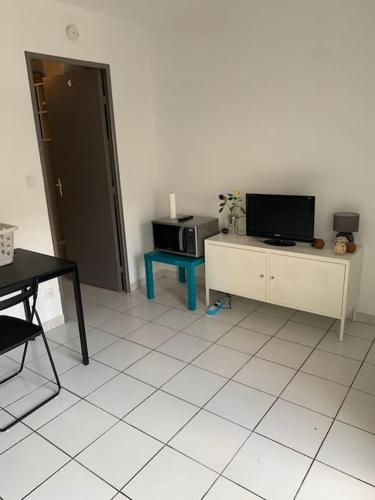 Il comprend un salon doté d'une télévision et de carrelage. dans l'établissement Le Vendome, à Nîmes