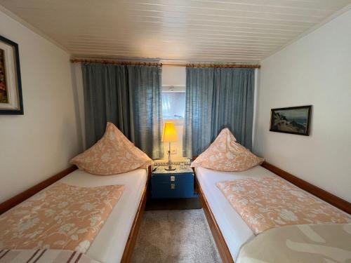 ein kleines Zimmer mit 2 Betten und einer Lampe in der Unterkunft Zur Himmelsleiter in Westerland