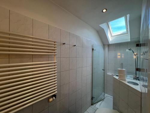 ein Badezimmer mit Dusche und Toilette und einem Fenster in der Unterkunft Zur Himmelsleiter in Westerland