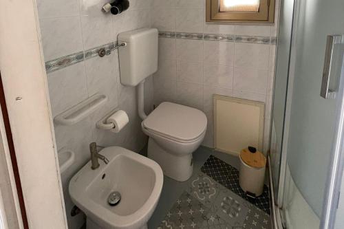 a small bathroom with a toilet and a sink at "Da Nina" in Lascari