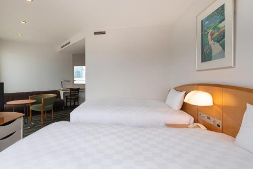 a hotel room with two beds and a table at Shinagawa Prince Hotel in Tokyo