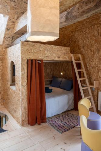 une chambre avec un lit dans un mur de pierre dans l'établissement La Ferme du golf, gîte atypique et artistique, à Lancieux