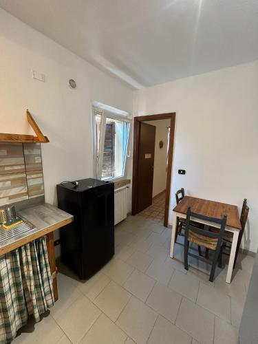 a kitchen with a table and a black refrigerator at Ca'Silvia in San Savino