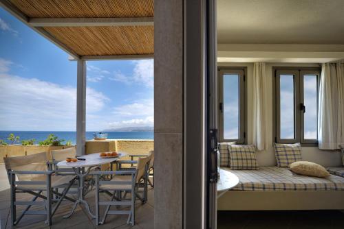 a room with a balcony with a table and chairs at Skajado Holiday Apartments in Stalida