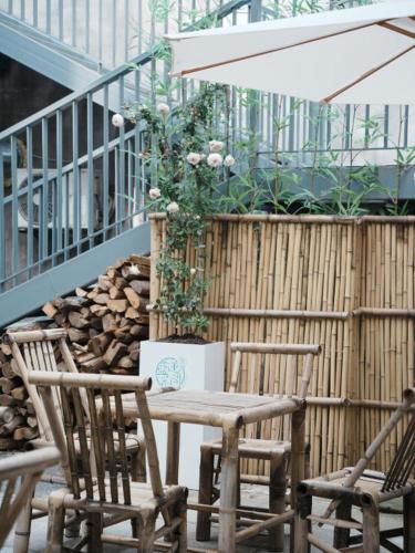 a patio with two chairs and a table and an umbrella at 新昌蓝莲花开大佛寺民宿 in Xinchang