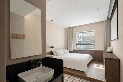 a bedroom with a bed and a sink and a mirror at 新昌蓝莲花开大佛寺民宿 in Xinchang