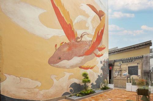 a painting of a fish on the side of a building at 新昌蓝莲花开大佛寺民宿 in Xinchang