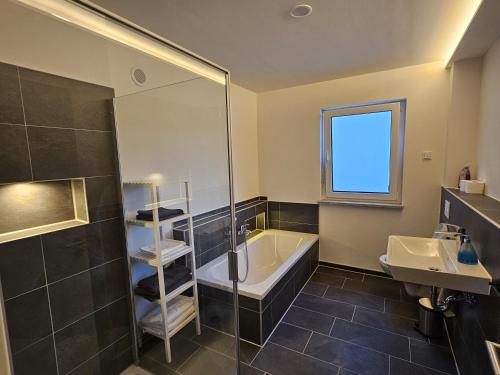 a bathroom with a shower and a tub and a sink at Ferienwohnung Auszeit in Solnhofen