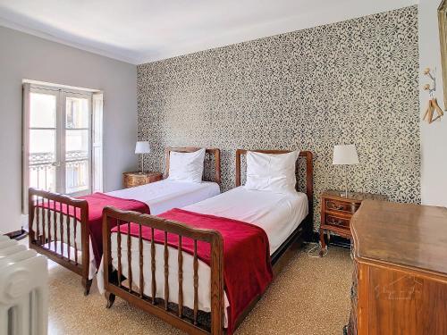 Un dormitorio con dos camas y una ventana. en Apartment Carcasses, en Carcassonne